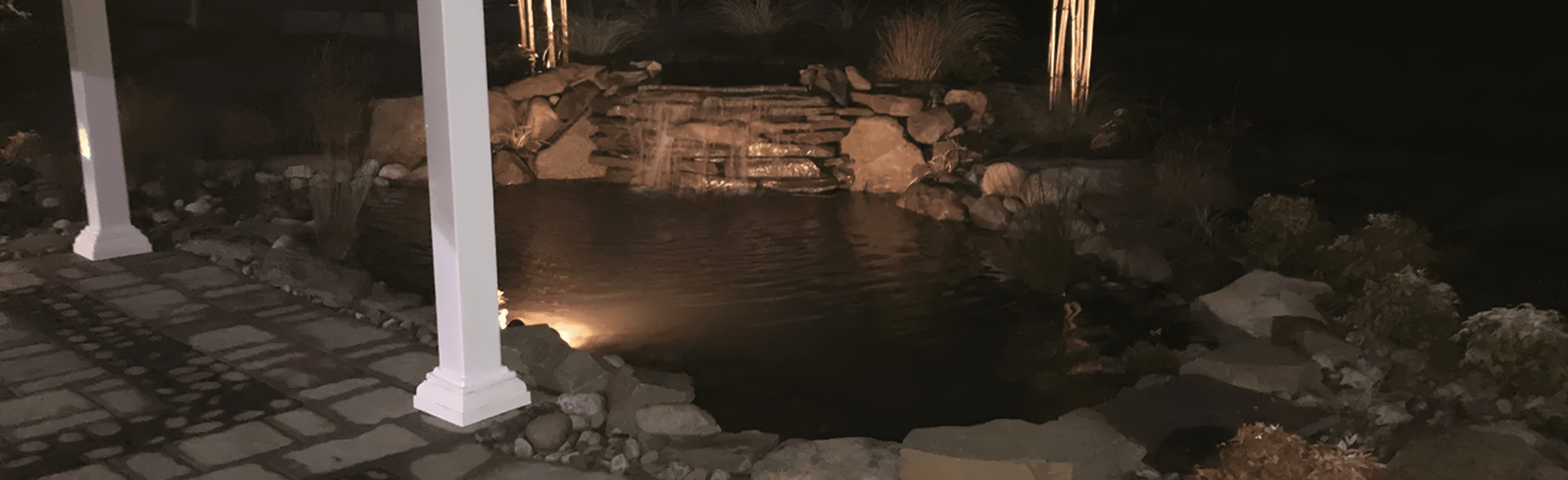 Nighttime garden pond with waterfall